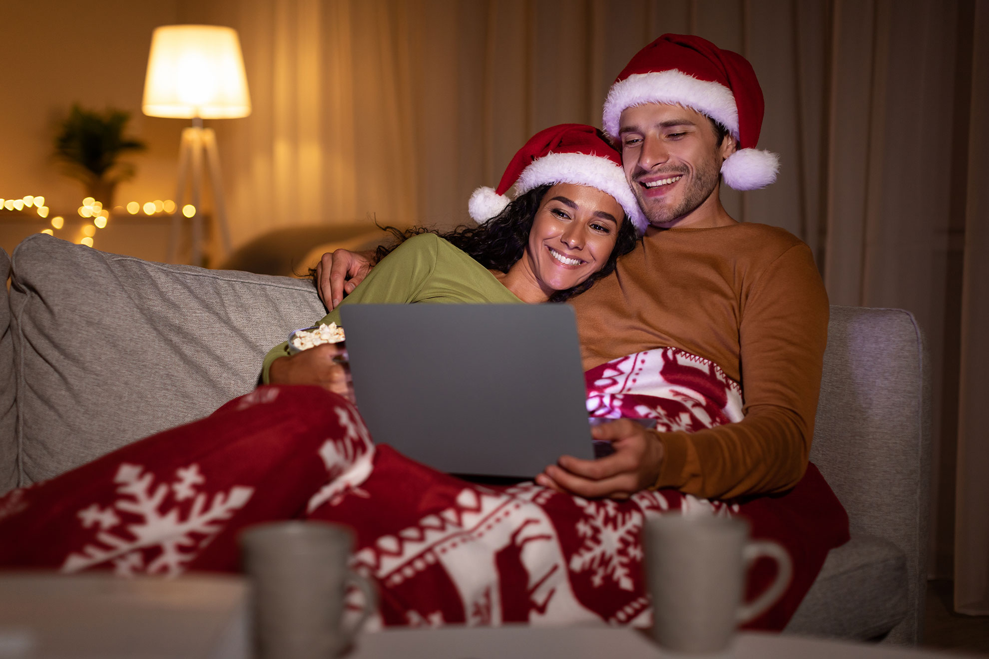 Para w świątecznej stylizacji oglądająca film na komputerze, ilustracja do artykułu