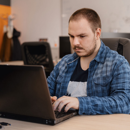 Mężczyzna pracuje przed komputerem, ilustracja do artykułu