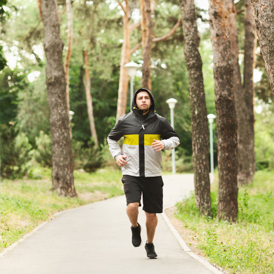 Mężczyzna biegnący w parku, ilustracja do artykułu o odchudzaniu podczas biegani