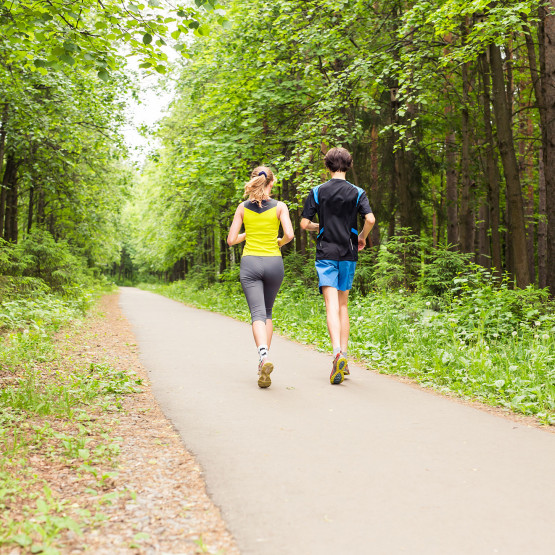 Para biegaczy biegnąca w lesie, ilustracja do artykułu o czasie w biegu na 10 km