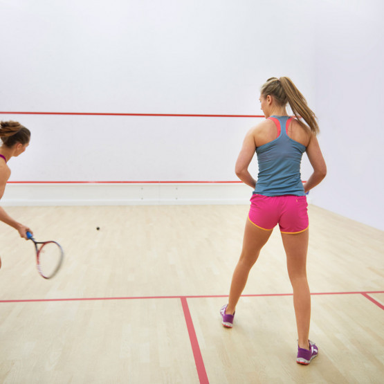 Dwie zawodniczki grające w squasha, ilustracja do artykułu o piłce z białą kropką