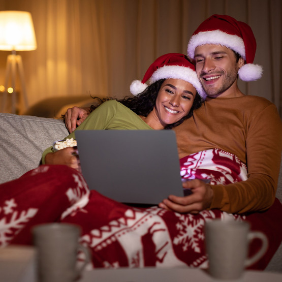 Para w świątecznej stylizacji oglądająca film na komputerze, ilustracja do artykułu