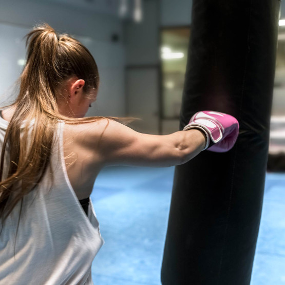 Kobieta trenująca na worku bokserskim, ilustracja do arykułu